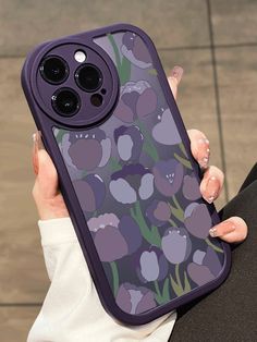 a woman holding an iphone case with purple flowers on it