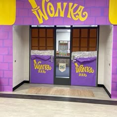 an entrance to a store with purple walls and yellow lettering on the doors that says wonka's