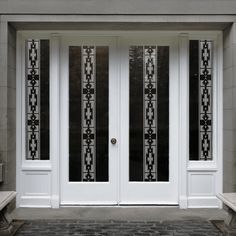 two white doors with decorative glass on each side and benches in the front yard behind them