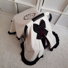 a white and black chair with a bow on it's seat cover sitting on the floor