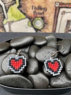 some kind of heart shaped earrings sitting on top of rocks