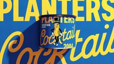 a can of coca - cola sitting on top of a blue and yellow sign that says planters