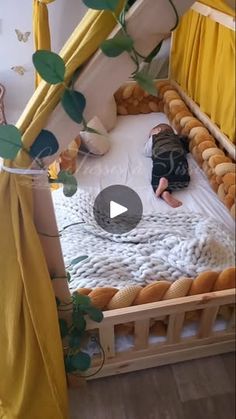 a person laying on top of a bed in a room with yellow curtains and pillows