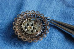 two metal pins sitting on top of a blue piece of cloth