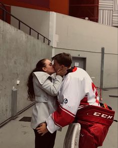 a man and woman kissing while standing next to each other