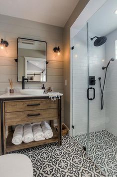 a bathroom with a sink, mirror and shower in it's center area next to a stand up shower