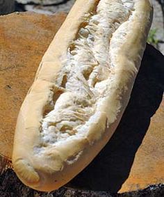 a hot dog bun sitting on top of a piece of wood