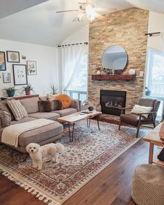 a living room filled with furniture and a dog standing in front of the fire place