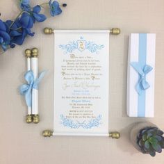 a blue and white wedding stationery set up on a table with flowers, keys, and other items