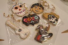 some decorated cookies are on a plastic wrapper in the shape of guitars and skeletons