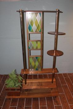 a wooden stand with three shelves and a plant