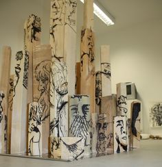 several pieces of wood are stacked on top of each other in an art gallery,