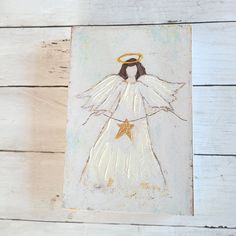 an angel painted on the side of a white wooden wall with a star in its hand