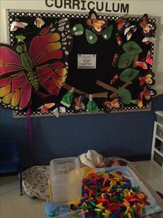 a bulletin board with lots of colorful magnets on it and a plastic container full of letters