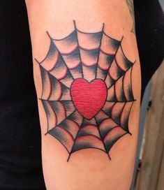 a spider web with a heart tattoo on it's arm is seen in this image