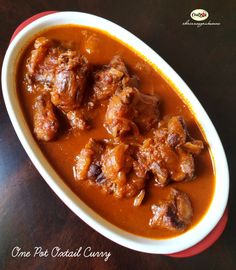 a bowl filled with meat and sauce on top of a table