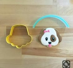 two cookie cutters on a wooden surface with a dog and bear shaped cookie in the middle