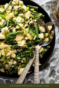 broccoli and cauliflower stir fry in a skillet with spoons