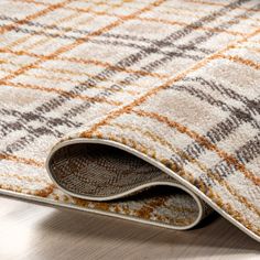 a close up of a rug on the floor with an area rug that has been made to look like a plaid pattern