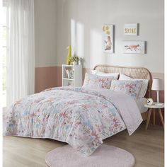 a bedroom with white walls and wooden flooring has a pink rug on the floor