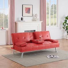 a red couch sitting on top of a wooden floor