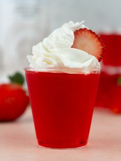 strawberry jello shots with whipped cream in a red cup