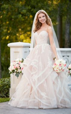 a beautiful woman in a wedding dress posing for the camera with her bridal bouquet