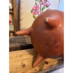 a clay pig sitting on top of a wooden table