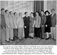 a group of people standing next to each other in front of a wall with writing on it