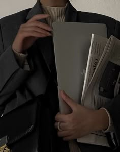 a woman is holding newspapers in her hands