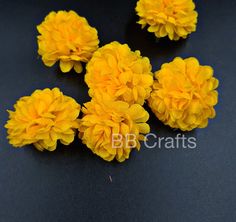 small yellow flowers are placed on a black surface with the words bb crafts above them