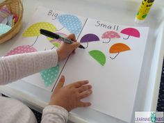 a child is writing on a card with umbrellas