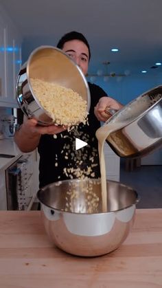 a woman is pouring some cereal into a large metal bowl on the kitchen counter top