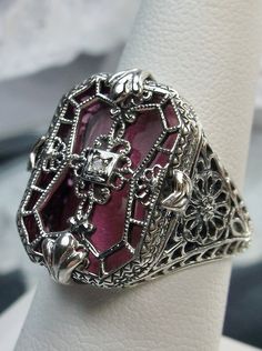 Pink Camphor Glass Ring with Sterling Silver Art Deco Filigree and a single white CZ in the center of the pane sections Antique Jeweled Jewelry For Formal Occasions, Antique Formal Jewelry, Ornate Formal Jewelry With Stone Setting, Collectible Diamond Jewelry With Intricate Design, Ornate Jewelry With Stone Setting For Formal Occasions, Ornate Jewelry For Formal Occasions With Stone Setting, Diamond Jewelry With Intricate Design For Collectors, Unique Formal Jewelry, Elegant Silver Filigree Ring With Stone Setting