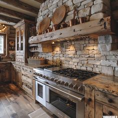 a rustic kitchen with an oven and stone wall