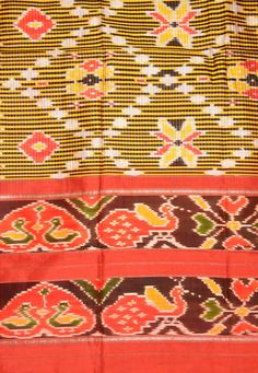 an orange, yellow and brown colored cloth with different designs on it's sides