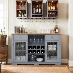 a grey cabinet with wine glasses and bottles on it in front of a wall mounted bar