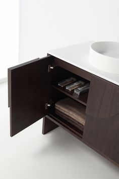 a bathroom vanity with a sink and wooden cabinet in the middle, on white flooring