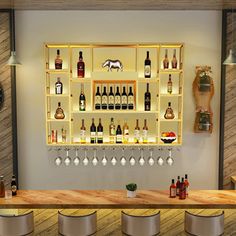 a bar with several bottles and glasses on the wall above it, along with stools