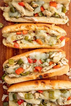 four hot dogs with different toppings on a wooden table