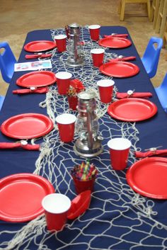 the table is set with red cups and plates