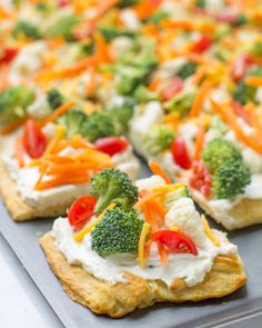 broccoli, carrots, and cheese pizza on a baking sheet