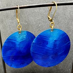 A 1 3/4 inch brass plate is hand painted in a vibrant gradation of blues for a beautiful and bold pair of earrings. They hang from gold-plated lever back ear wires. Crafted in Salem, MA. Salem Ma, Brass Plate, Pitcairn Islands, Round Earrings, Turks And Caicos Islands, Ear Wires, Trinidad And Tobago, 4 Inch, Plating