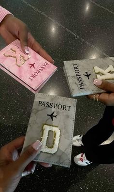 two people holding passport cards with letters and numbers on them, while another person holds one