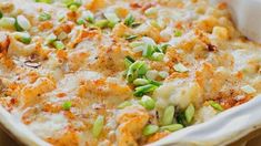 a casserole dish with green onions and cheese