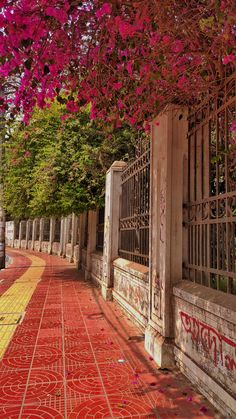 an old building with red tiles and flowers on the ground