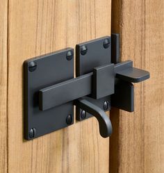 a close up of a door handle on a wooden door with black handles and latches