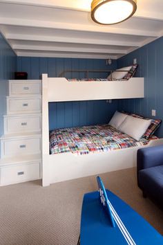 there is a bunk bed in the room with blue walls and white drawers on it