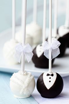 some white and black cake pops are on a plate with the words trend we love mini desserts