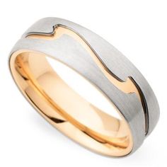 two tone gold and silver wedding ring with wavy lines on the outside, set against a plain white background